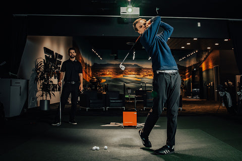 Golfer swinging club during a club fitting